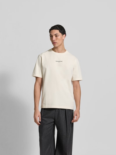 Männermodel trägt Regular Fit T-Shirt aus Baumwolle von MAISON KITSUNÉ, beige, kurzer Schnitt, Rundhalsausschnitt, Ganzkörperansicht von vorne.