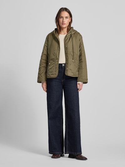 Frauenmodel trägt Relaxed Fit Funktionsjacke mit Woll-Füllung Modell 'AGRESTE' von Weekend Max Mara, oliwkowa, jednolita, kaptur, długie rękawy, logo na rękawie, wodoodporna, kieszenie boczne, widok całej sylwetki z przodu.