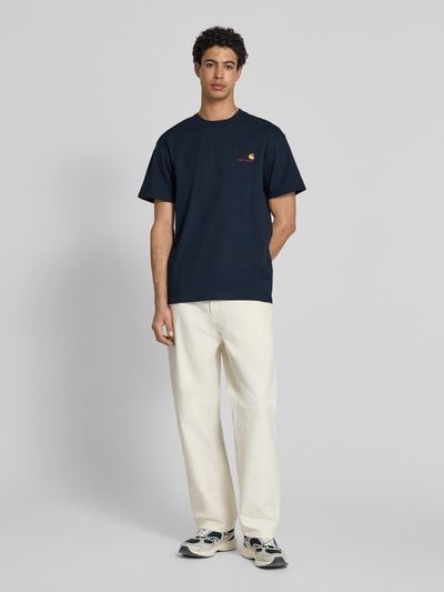 Männermodel trägt T-Shirt mit Label-Stitching und Rundhalsausschnitt von Carhartt Work In Progress, Reine Baumwolle, Regular-Fit, Herren T-Shirt, Rückenlänge 73 cm bei Größe M, Ganzkörperansicht von vorne