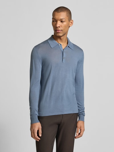 Männermodel trägt Slim Fit Poloshirt aus reiner Wolle Modell 'Eross' von Tiger Of Sweden in Hellblau, Strick-Optik, Ganzkörperansicht von vorne.