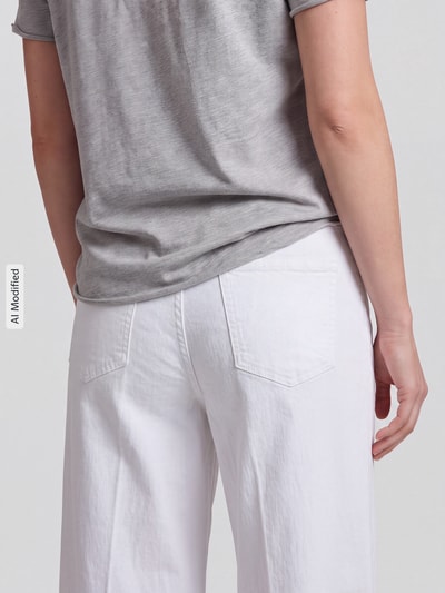 Frauenmodel trägt Wide Leg Jeans mit Bindegürtel Modell 'WENDY' von MAC aus Baumwoll-Elasthan-Mix in Weiß, Nahaufnahme Rückansicht, KI-modifiziertes Bild.
