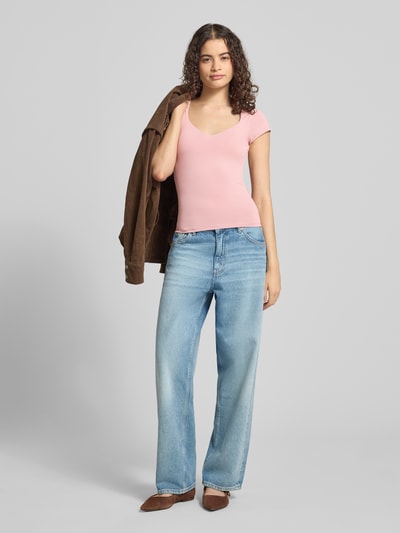 Frauenmodel trägt T-Shirt mit integriertem BH von Gina Tricot, Damen T-Shirt im Slim-Fit aus Material-Mix mit Stretch-Anteil, Rundhalsausschnitt, Rückenlänge 52 cm bei Größe S, zarte Rosa-Töne, glatte Textur, Ganzkörperansicht von vorne.