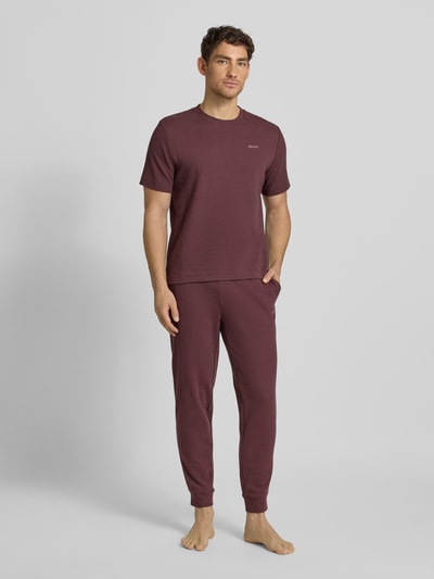 Männermodel trägt Relaxed Fit Pyjama-Hose aus Baumwoll-Mix Modell 'AUSTIN PANTS' von HUGO, Optik: Unifarben, Waffel-Struktur, Regular-Fit, Label-Print, Tunnelzug, seitliche Eingrifftaschen, Ganzkörperansicht von vorne