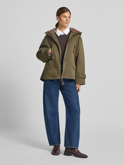 Frauenmodel trägt Jacke mit Zweiwege-Reißverschluss und Ärmelriegeln von Blonde No. 8 in Olivgrün, Regular Fit, Kunstfell, Ganzkörperansicht von vorne. Baumwoll-Elasthan-Mix, Pattentaschen, Rückenlänge 65 cm, Schulterbreite 55 cm, Brustweite 65 cm, Ärmellänge 53 cm