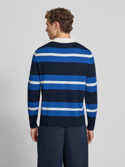 Männermodel trägt Regular Fit Poloshirt aus Viskose-Mix von MCNEAL in Blau mit Streifen, elastische Abschlüsse, Ganzkörperansicht Rückansicht.