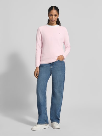 Vrouwenmodel draagt Regular Fit Pullover aus reiner Baumwolle van Tommy Hilfiger, roze, rondhals, lange mouw, logo-stiksel, ribgebreid, katoen, vooraanzicht hele lichaam