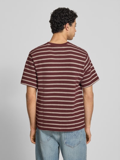 Männermodel trägt Strukturiertes T-Shirt mit Logostickerei auf der Brust von REVIEW, Reine Baumwolle, Gerader-Schnitt, Rundhalsausschnitt, Label-Stitching, Lochstickerei, Strukturmuster, Rückenlänge bei Größe M: 70 cm, gestreiftes Design in Braun und Beige, Ganzkörperansicht Rückansicht.