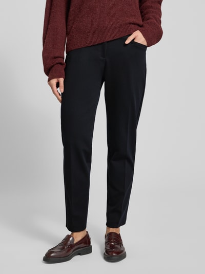 Vrouwenmodel draagt Hose mit elastischem Bund und Bügelfalten Modell 'MARON' van Brax, zwarte stof, cropped fit, voorkant zicht, close-up onderlichaam, mix van materialen met viscose, elastische tailleband, persvouwen, context: damesbroek met taillewijdte 41 cm en binnenbeenlengte 70 cm bij maat 36.