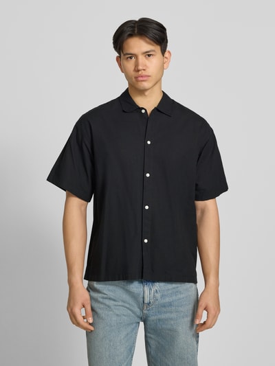 Männermodel trägt schwarzes Regular Fit Freizeithemd aus Baumwoll-Leinen-Mix von Jack & Jones, Kentkragen, Knopfleiste, Ganzkörperansicht von vorne.