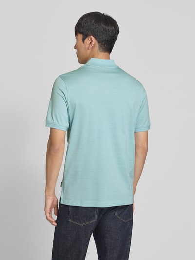 Männermodel trägt Regular Fit Poloshirt mit Strukturmuster von bugatti in Hellblau aus Reine Baumwolle, Rückenlänge 70 cm, Ganzkörperansicht Rückansicht.