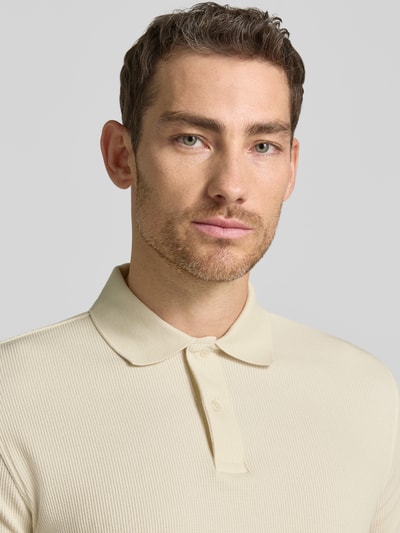 Männermodel trägt Regular Fit Poloshirt aus Baumwoll-Mix Modell 'BLAZE' von SELECTED HOMME, Struktur, Optik: Unifarben, Nahaufnahme Oberkörper.