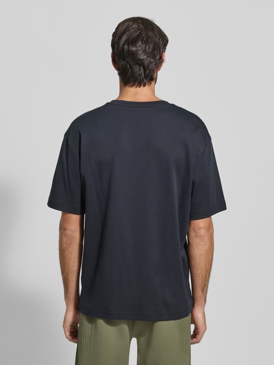 Männermodel trägt Relaxed Fit T-Shirt aus reiner Baumwolle Modell 'JOIN' von BOSS Green, unifarben, Kurzarm, Rückansicht Ganzkörperansicht.