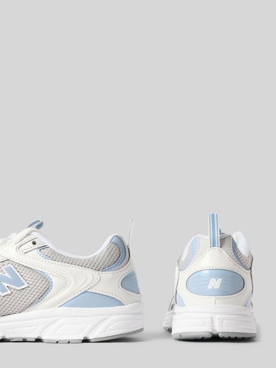 Produktfoto, Sneaker mit Kontrastbesatz von New Balance, weiße und hellblaue Farbtöne, strukturierte Sohle, sichtbares Logo, rundes Design, abgerundete Schuhform, Schnürverschluss, Kontrastdetails, Schafthöhe 7 cm, Schaftweite 9 cm, Absatzhöhe 3 cm bei Größe 40