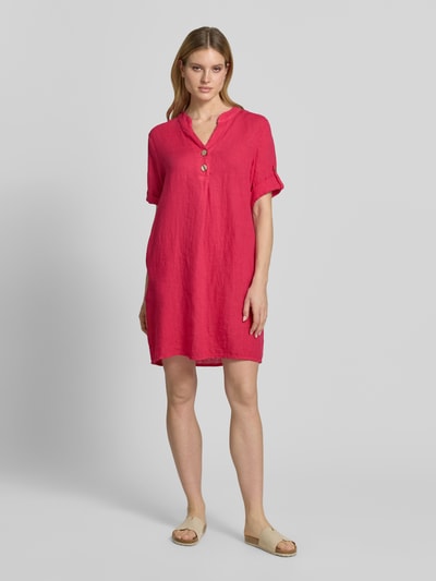 Frauenmodel trägt Tunikakleid aus Leinen mit V-Ausschnitt Modell 'Ki44ra' von ZABAIONE in Pink mit Knopfleiste, Ärmel mit Aufschlag, Gerader-Schnitt, Rückenlänge 95 cm, Brustweite 50 cm, Ärmellänge 26 cm; Ganzkörperansicht von vorne.
