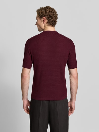 Männermodel trägt Slim Fit Strickshirt aus reiner Wolle von Emporio Armani in Dunkelrot, gerippte Abschlüsse, Ganzkörperansicht Rückansicht.