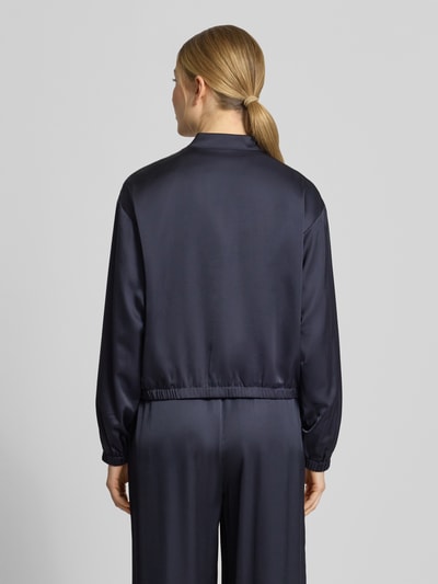 Frauenmodel trägt Blouson mit Stehkragen und Reißverschluss von Comma, dunkelblau, Material-Mix mit Viskose-Anteil, Regular-Fit, Rückenlänge 52 cm, Brustweite 50 cm, Ärmellänge 57 cm, glatte Oberfläche, Ganzkörperansicht Rückansicht.