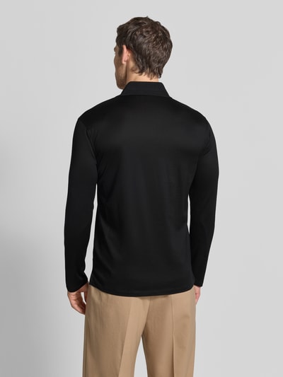 Männermodel trägt Slim Fit Poloshirt aus Lyocell-Mix von Emporio Armani in Schwarz, glatte Textur, Ganzkörperansicht Rückansicht.