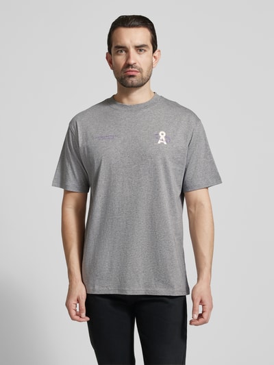 Männermodel trägt Relaxed Fit T-Shirt aus reiner Bio-Baumwolle Modell 'MAARKOS' von Armedangels in Unifarbe, Logo Print, Jersey, Ganzkörperansicht von vorne.