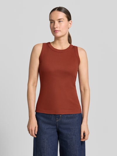 Modelka kobieca nosi Tanktop mit Rundhalsausschnitt Modell 'OLINA' od Drykorn, bawełna, krój slim fit, kolor ceglasty, drobny prążek, zdjęcie całej sylwetki z przodu.