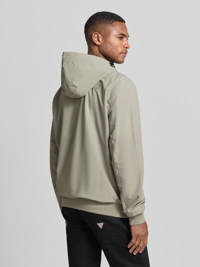 Męski model nosi kurtkę Jacke mit Reißverschlusstaschen Modell 'MATTEO' von CARS JEANS, mieszanka materiałów z dodatkiem streczu, krój regular fit, kaptur z tunelem, zamek błyskawiczny, kieszenie zapinane na zamek błyskawiczny, długość tyłu w rozmiarze M: 70 cm, szerokość ramion w rozmiarze M: 44 cm, szerokość klatki piersiowej w rozmiarze M: 50 cm, długość rękawów w rozmiarze M: 70 cm, jasny odcień beżu, matowa faktura, pełny tył; Ganzkörperansicht Rückansicht.