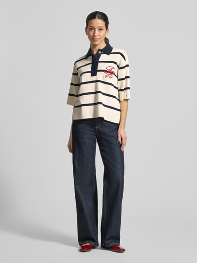 Vrouwenmodel draagt Regular Fit Poloshirt aus Bumwoll-Mix van Tommy Hilfiger met all-over motief en gestikt logo, fijngebreid katoenmix, voorkant geheel te zien