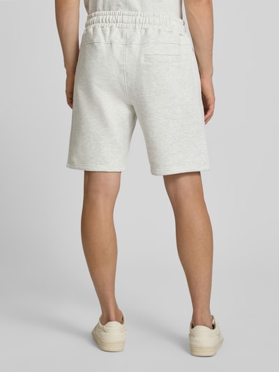 Männermodel trägt Sweatshorts mit Label-Stitching Modell 'Lido' von PEGADOR, Baumwoll-Mix, helle Farbe, Regular Fit, Ganzkörperansicht Rückansicht.
