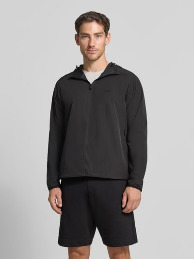 Männermodel trägt schwarze Regular Fit Trainingsjacke mit Label-Print Modell 'OW_Airynix JT HD 2' von BOSS Green, Ganzkörperansicht von vorne.