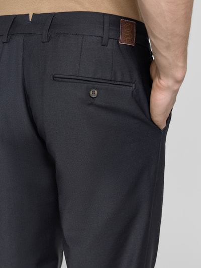 Männermodel trägt Straight Fit Stoffhose mit Woll-Anteil von g1920 in dunklem Anzug-Stoff: Bundfalten, Gesäßtasche, Elastischer-Material-Mix, Nahaufnahme Rückansicht.