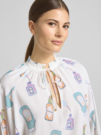 Modelka kobieca ma na sobie Regular Fit Cardigan aus Seiden-Mix in Strick-Optik von HERZENS, elastyczny jedwabny materiał, krój regular fit, tekstura dzianiny, dopasowany w talii, odpinany materiałowy pasek, długość tyłu w rozmiarze 36: 62 cm, długość rękawa w rozmiarze 36: 55 cm, jasne kolory z nadrukiem butelek, bliskie ujęcie górnej części ciała