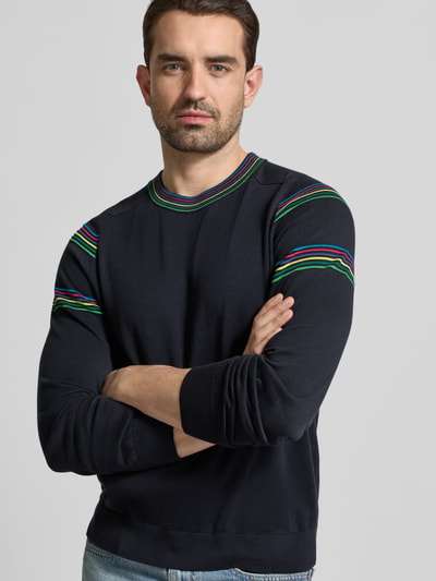 Männermodel trägt Pullover mit Rundhalsausschnitt und Kontraststreifen von PAUL SMITH in Dunkelblau mit bunten Streifen, Regular Fit, Nahaufnahme Oberkörper.