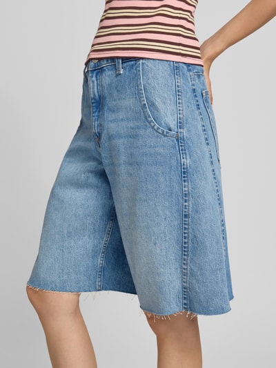 Frauenmodel trägt Straight Fit Shorts in Denim-Optik Modell 'Joa' von Topshop mit Eingriff- und Gesäßtaschen, Nahaufnahme Oberkörper.