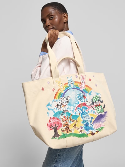 Frauenmodel trägt Shopper aus reiner Baumwolle von Kenzo mit buntem Print, langen Schulterriemen und kurzen Tragehenkeln, Nahaufnahme Oberkörper. Offenes Hauptfach mit Druckknopfverschluss, Innenfach, Maße bei Größe 1: Breite 54 cm, Länge 35 cm, Tiefe 17 cm.