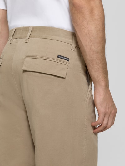 Männermodel trägt Weite Hose aus Baumwoll-Mix Modell 'Mossbo' von Marc O'Polo in Beige, glatte Textur, Nahaufnahme Rückansicht, Herren Weite Hose von Marc O'Polo.