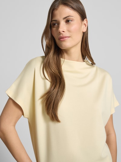 Vrouwenmodel draagt Regular Fit T-Shirt uit elastische viscose-mix, model 'Kiline' van Someday, lichte kleur, opstaande kraag, close-up bovenlichaam.