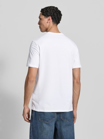 Männermodel trägt T-Shirt mit Rundhalsausschnitt und Logo von Calvin Klein Jeans in Weiß, reine Baumwolle, Regular Fit, Ganzkörperansicht Rückansicht.