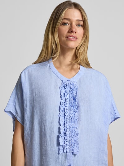 Frauenmodel trägt Relaxed Fit Leinenbluse mit Rüschen von Milano Italy in hellblau, reine Leinenstruktur, Nahaufnahme Oberkörper.