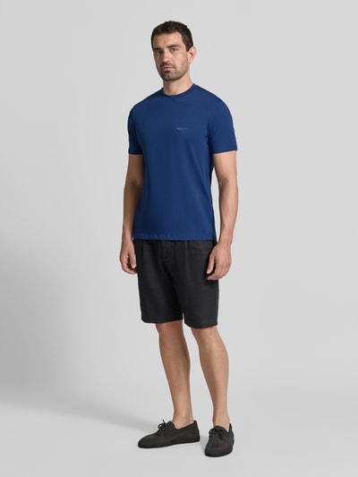 Męski model nosi Extra Slim Fit T-Shirt mit Rundhalsausschnitt von Armani Exchange w kolorze niebieskim, Logo, Długość tyłu w rozmiarze M: 70 cm, Ganzkörperansicht von vorne