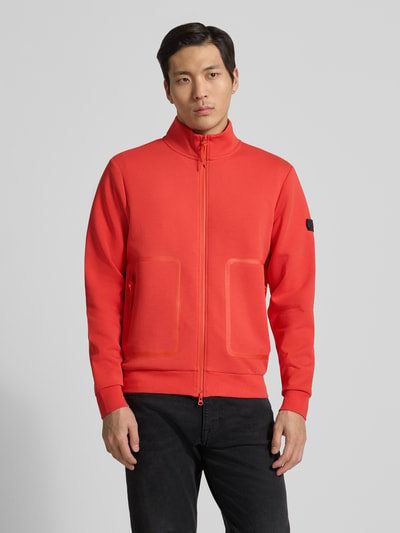 Męski model nosi Regular Fit Jacke mit Stehkragen Modell 'Scott' od Peuterey w czerwieni, mieszanka elastycznej bawełny, kieszenie, dwukierunkowy zamek, elastyczne wykończenia, długość tyłu i rękawa 66 cm w rozmiarze M, Ganzkörperansicht von vorne.