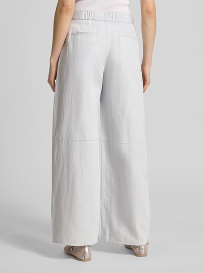 Frauenmodel trägt Wide Leg Pants mit Leinen-Anteil Modell 'SAROKO' von Samsøe Samsøe, helle Farbe, strukturierte Baumwollmischung, ausgestellter Schnitt, Bund und Gesäßtaschen sichtbar, Ganzkörperansicht Rückansicht.