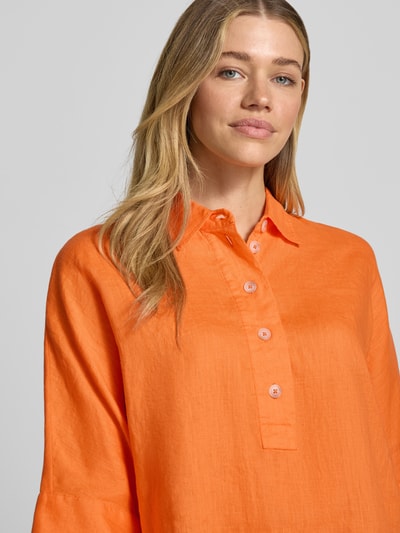 Vrouwenmodel draagt Regular Fit Leinenbluse mit 3/4-Arm van Emily Van den Bergh in effen oranje linnen met overhemdkraag en knoopsluiting, Nahaufnahme bovenlichaam.