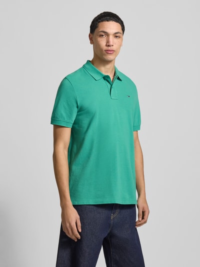 Mannenmodel draagt Regular Fit Poloshirt uit puur katoen van Tommy Jeans, look: effen, gestikt logo, piqué, korte mouw, rompzoom met splitten, geheelopname voorkant.
