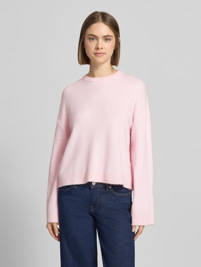Frauenmodel trägt Relaxed Fit Strickpullover mit Crew Neck Modell 'SIMONI' von Only, Melange-Optik, rosa, lange Ärmel, gerippte Abschlüsse, Ganzkörperansicht von vorne.