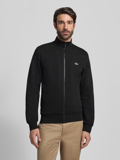 Männermodel trägt Regular Fit Sweatjacke aus Baumwoll-Mix von Lacoste in Optik: Unifarben, mit Stehkragen und Reißverschluss, Ganzkörperansicht von vorne.