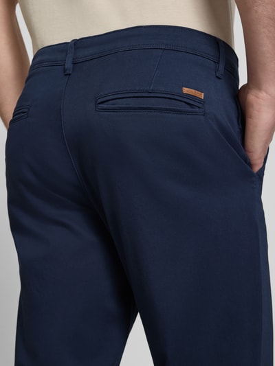 Männermodel trägt Slim Fit Hose in Knöchellänge Modell 'Marco' von Jack & Jones in Dunkelblau, Baumwoll-Mix, Detailaufnahme Rückansicht, Eingriff- und Gesäßtaschen, Knopf- und Reißverschluss, Bundweite 41 cm, Innenbeinlänge 74 cm.