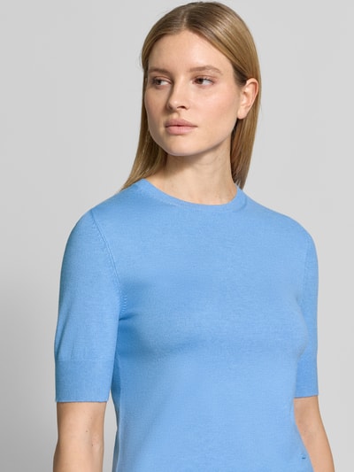 Modelka kobieca nosi Slim Fit T-Shirt aus Viskose-Mix od s.Oliver RED LABEL w kolorze jasnoniebieskim, imitacja dzianiny, drobny splot, aplikacja z metką, okrągły dekolt, krótki rękaw, mieszanka wiskozy; zbliżenie na górną część ciała z przodu