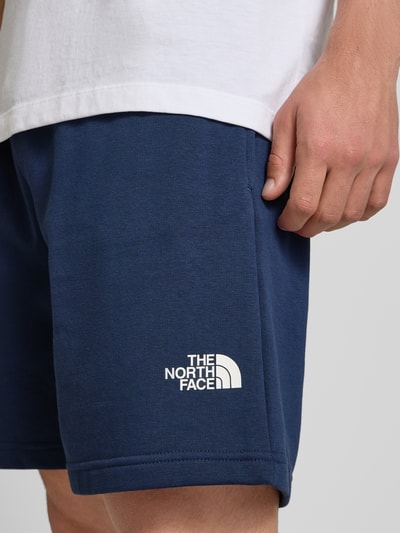 Männermodel trägt Shorts mit Logo von The North Face in Dunkelblau aus Baumwoll-Mix, Regular-Fit, Nahaufnahme Oberschenkel.