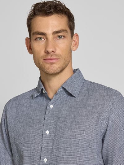 Männermodel trägt Regular Fit Freizeithemd aus Leinen-Baumwoll-Mix von MCNEAL in Blau mit Kentkragen und Knopfleiste, Nahaufnahme Oberkörper. Rückenlänge bei Größe M: 74 cm, Schulterbreite: 48 cm, Ärmellänge: 66 cm.