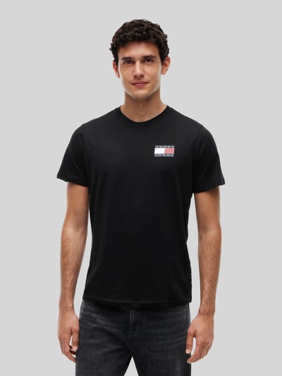 Männermodel trägt schwarzes Slim Fit T-Shirt aus reiner Baumwolle von Tommy Jeans, schlichtes Design, Nahaufnahme Oberkörper. Herren T-Shirt von Tommy Jeans