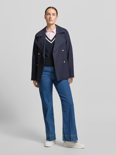 Kobiece model prezentuje Jeans mit seitlichen Knöpfen und Gesäßtaschen od Gant w kolorze niebieskim, mieszanka bawełny z dodatkiem streczu, krój regular fit, z bocznymi guzikami i kieszeniami z tyłu, szerokość w rozmiarze 27: 35 cm, długość wewnętrzna nogawki w rozmiarze 27: 80 cm, pełny widok z przodu.