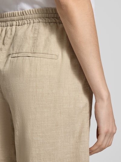 Frauenmodel trägt Bermudas mit elastischem Bund und Kordelzug Modell 'Lia Urban' von Angels aus Reine Baumwolle in Beige, Detailaufnahme Gesäßleistentasche, Loose-Fit, sichtbare Textur, Damen, Bundweite 40 cm, Innenbeinlänge 26 cm.